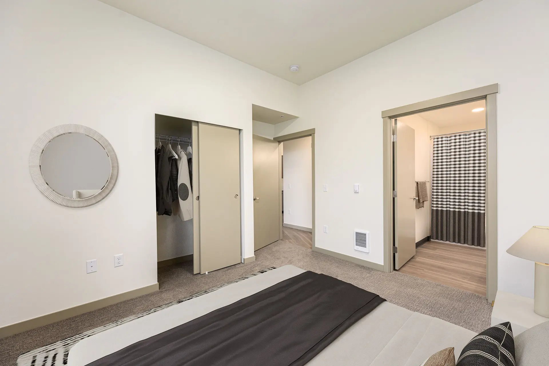 bedroom with view from the bed of the closet with sliding doors, and door open to the bathroom to the right.