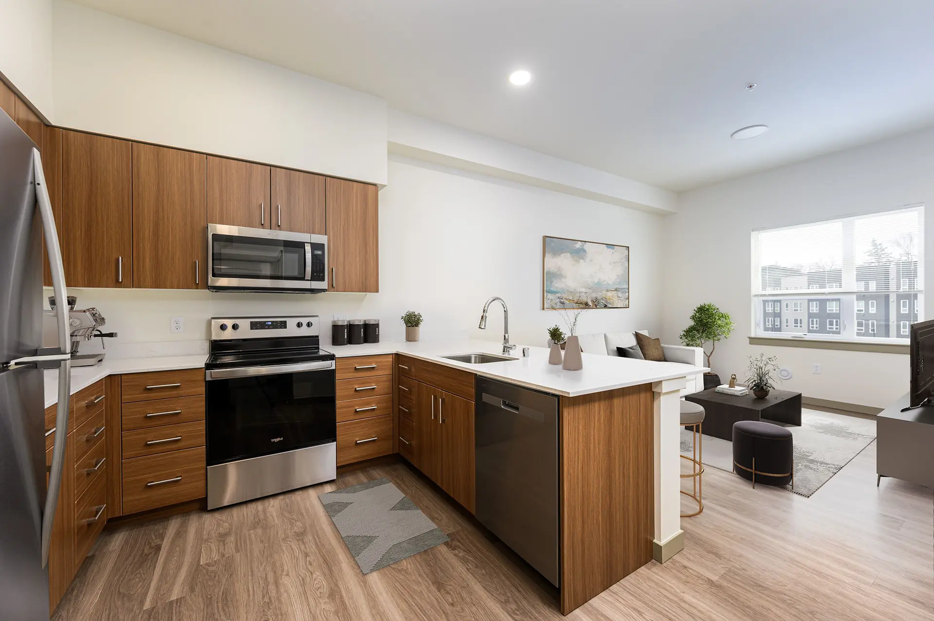 U-shaped kitchen with bar open to the living room which has a large wide window.