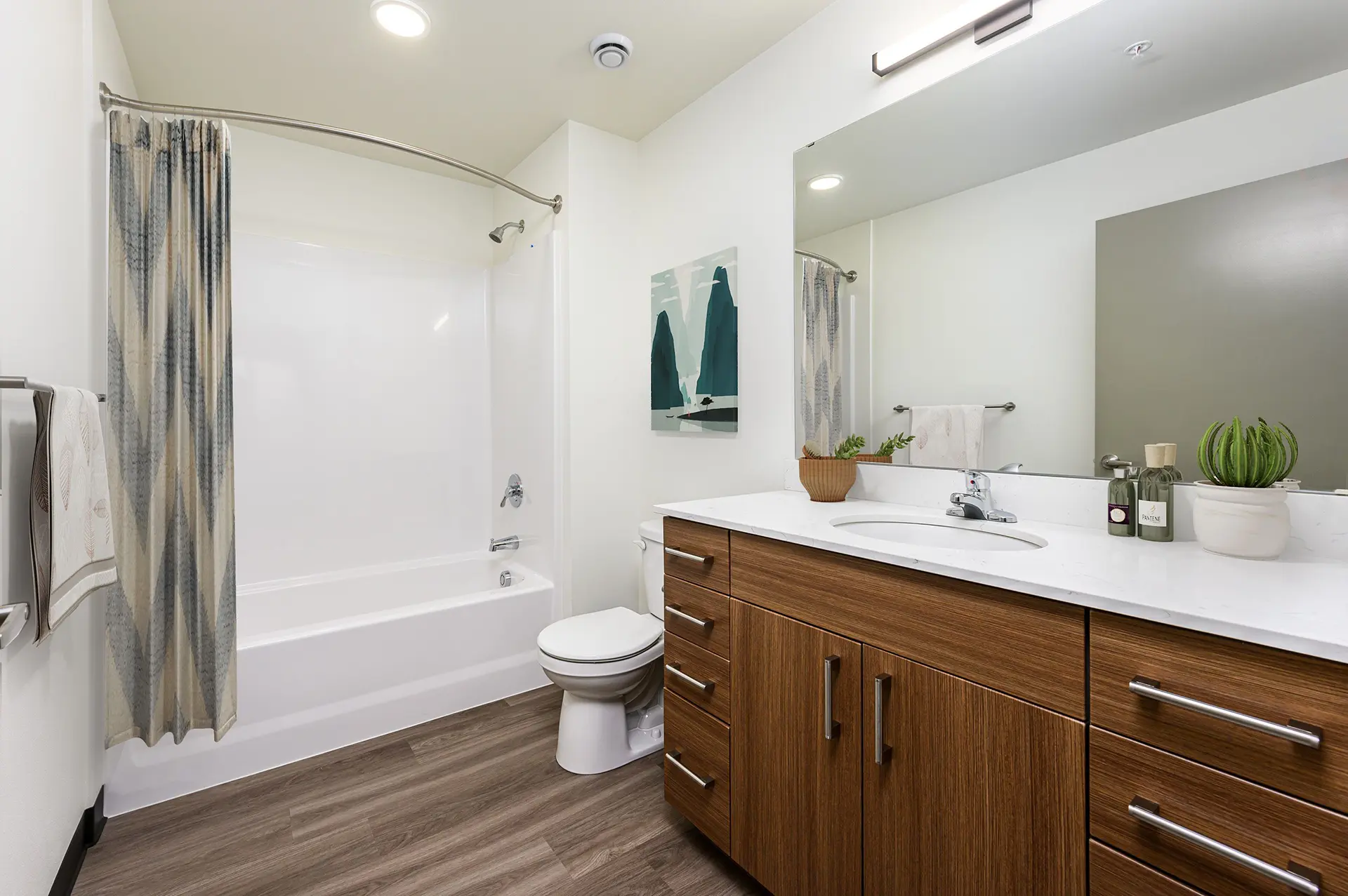 bathroom with single vanity next the toilet and a shower/tub combo with curved curtain rod.