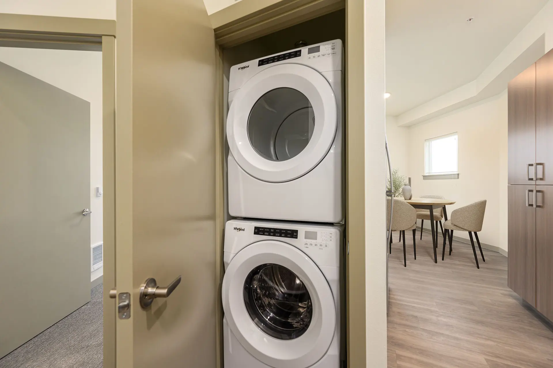 stacked front loading washer and dryer in a hall closet