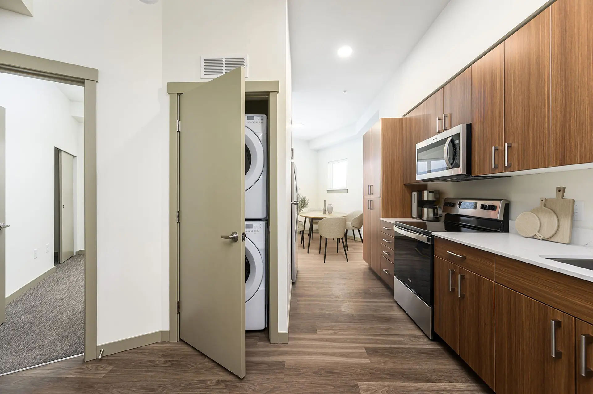 galley kitchen with ample cabinets next to stacked washer and dryer in a closet