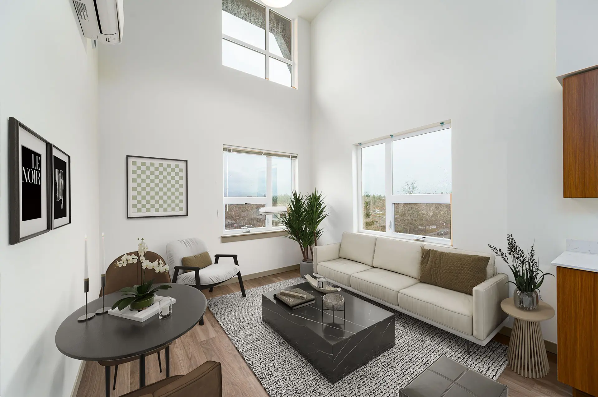 living room with light brown wood flooring, two seat dining table, modern rectangular white couch, high ceilings, and large windows with view of the horizon.